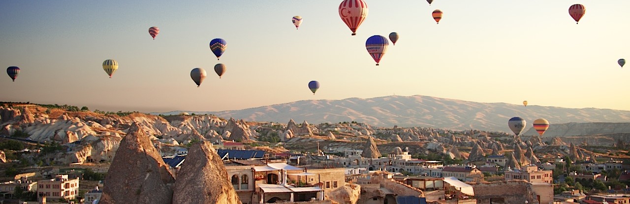 Sunrise In Cappadocia, Turkey, With Balloons And Typical Fairy Chimney